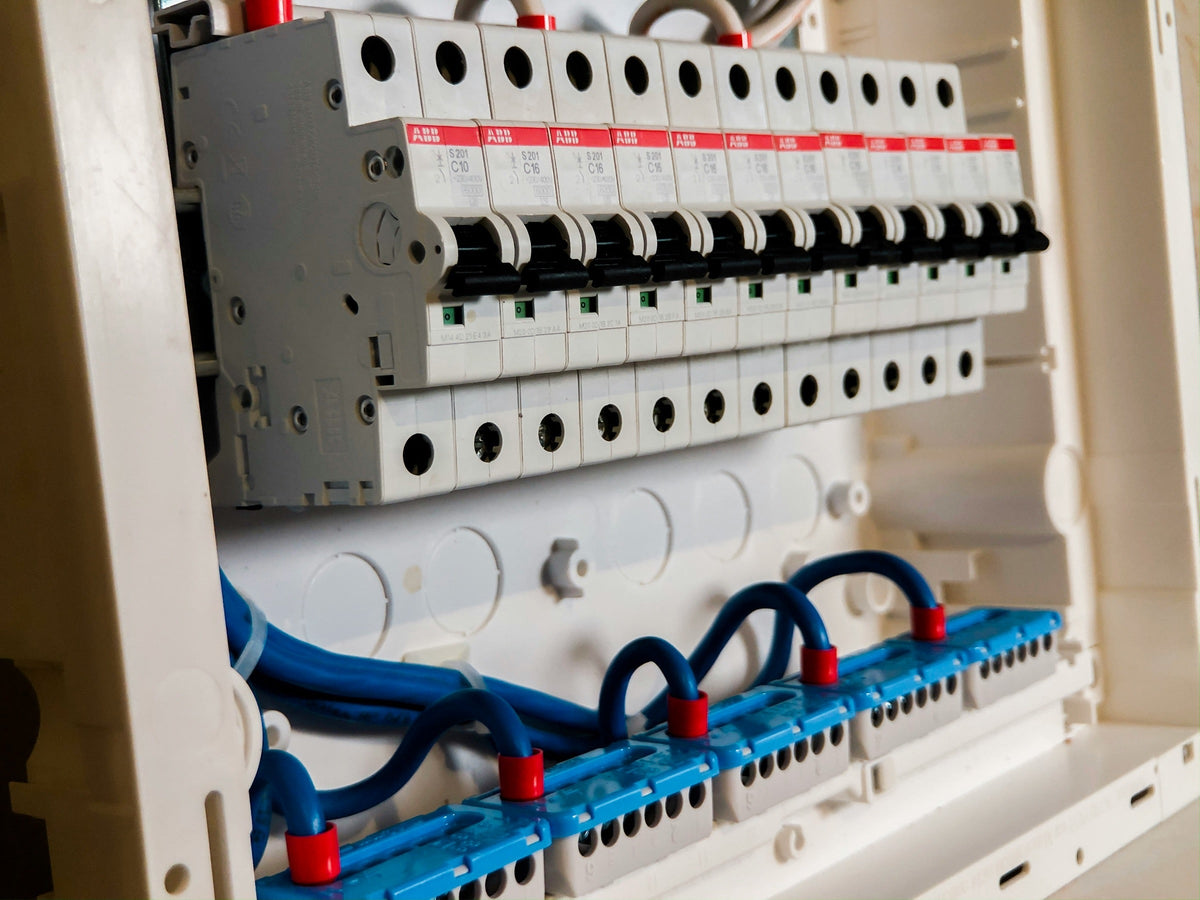 Geöffneter Kleinverteiler mit einer Reihe Leitungsschutzschalter und blau verdrahteten Neutralleiterklemmen
