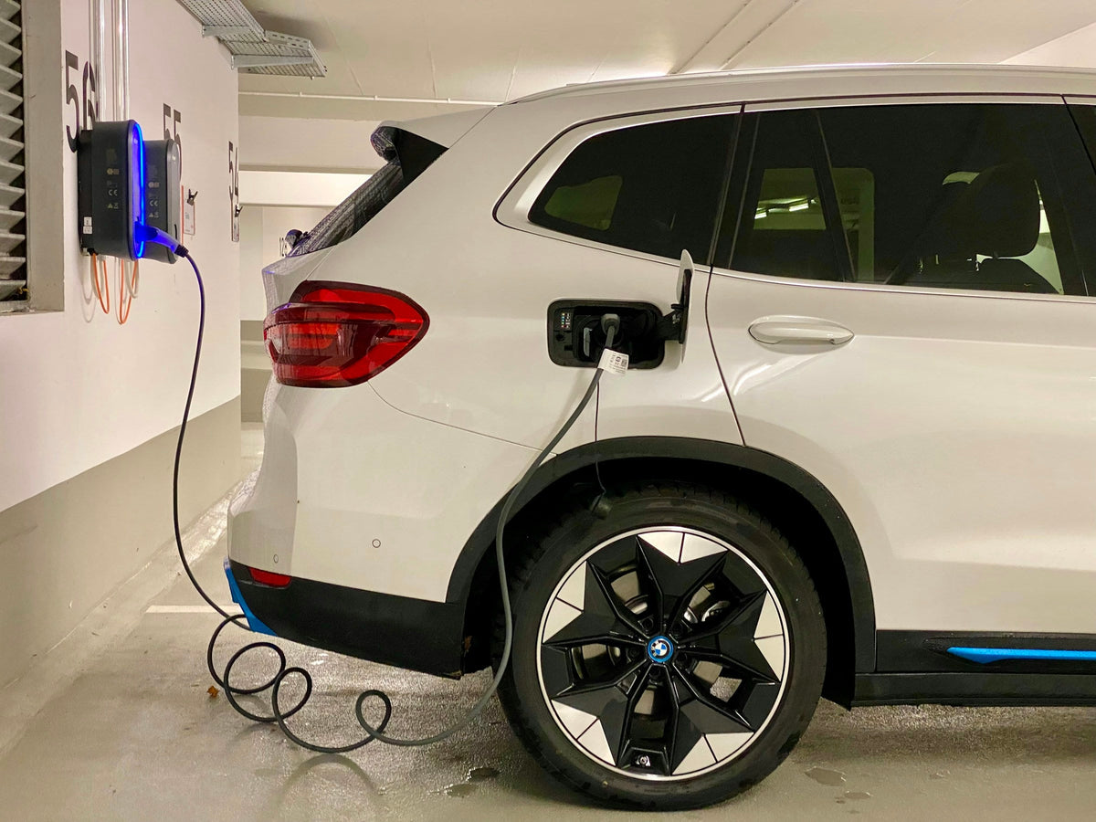 Elektroauto lädt an einer Wallbox in der Tiefgarage eines Mehrfamilienhauses