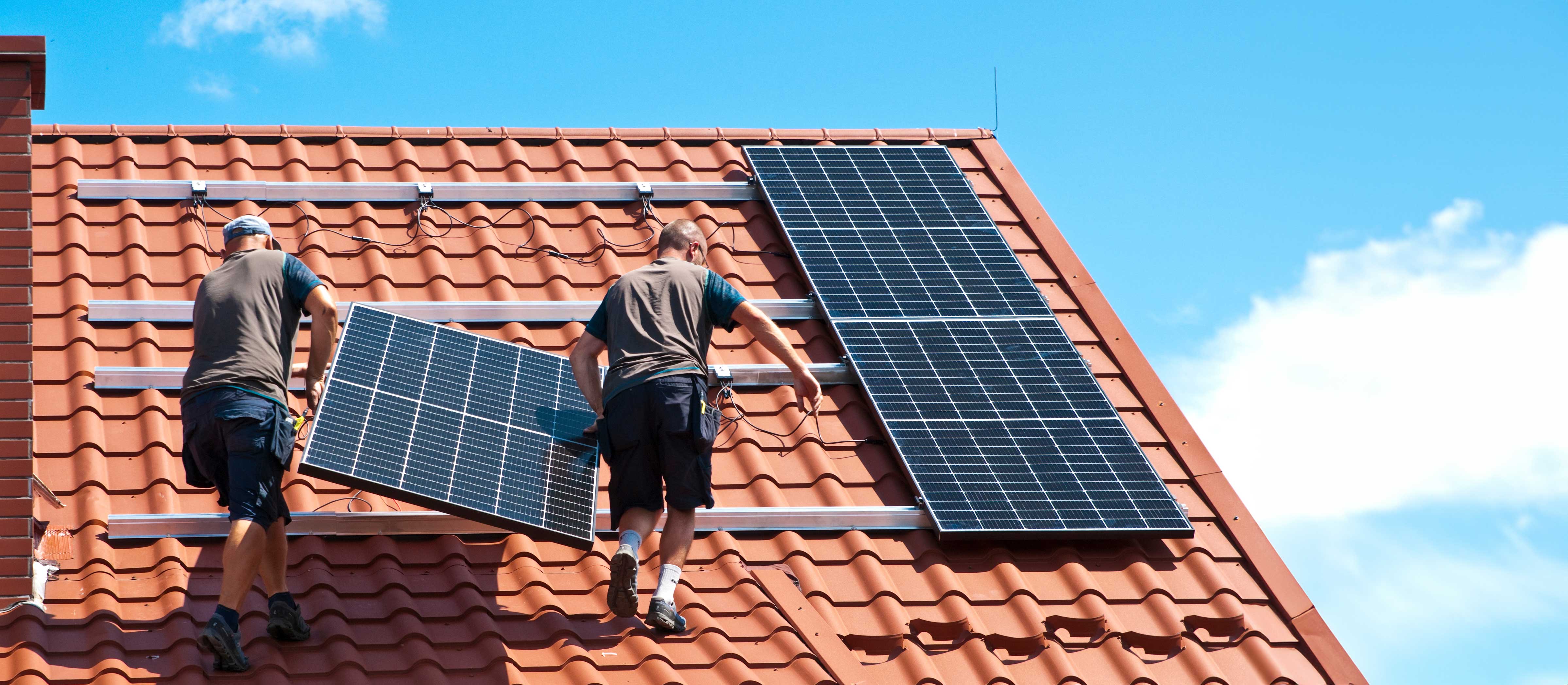 Techniker montieren Solarpanels auf einem Ziegeldach in Reutlingen, realisiert durch SKA Elektrotechnik