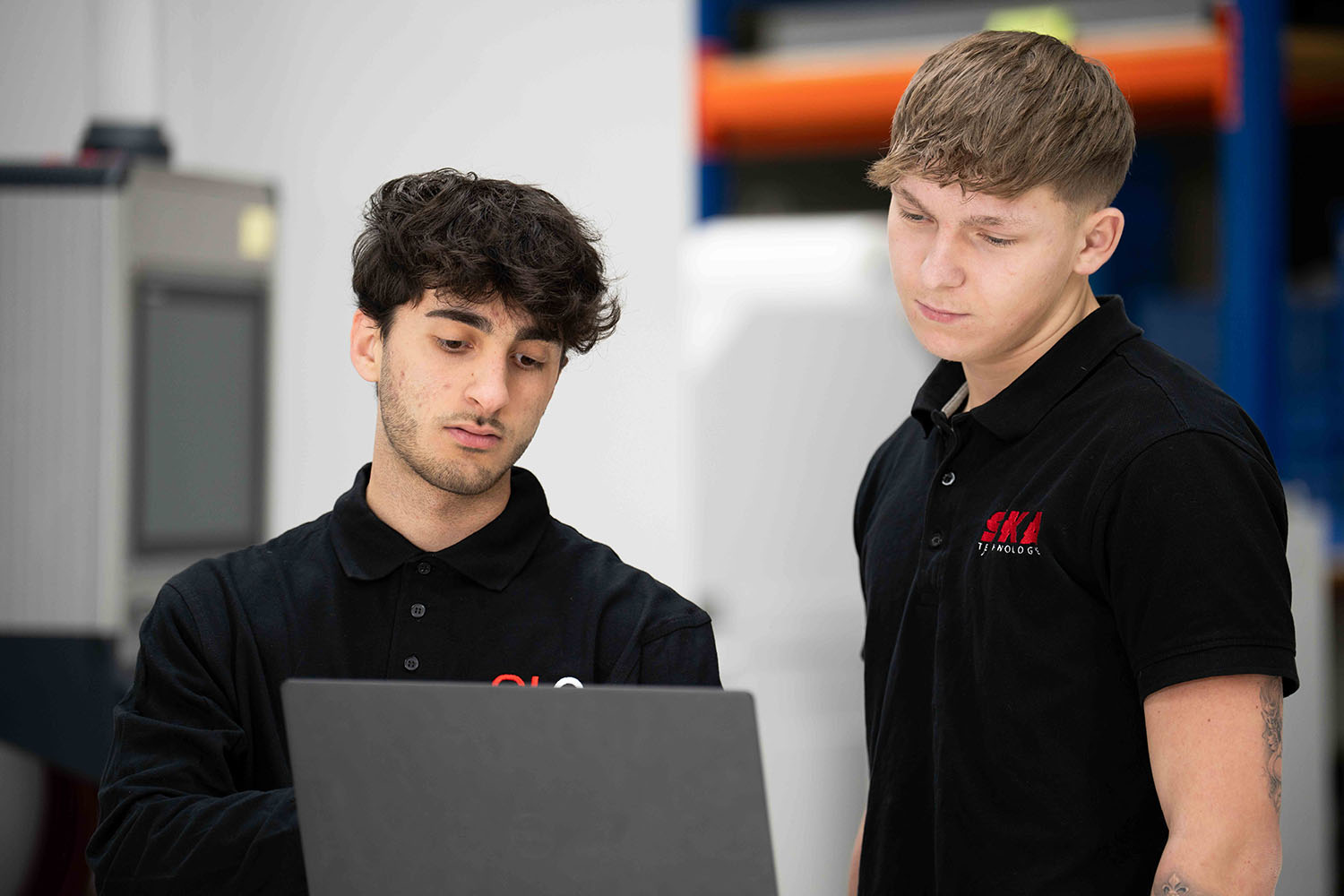 Zwei Mitarbeiter der SKA Elektrotechnik in Reutlingen arbeiten gemeinsam an einem Laptop, um ein Projekt zu planen